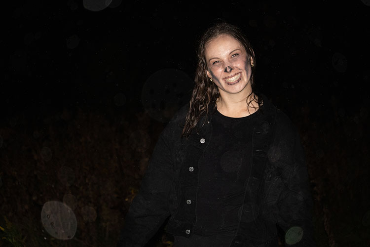PNW student poses with a smile for picture in skeleton makeup at the Haunted Trails event.