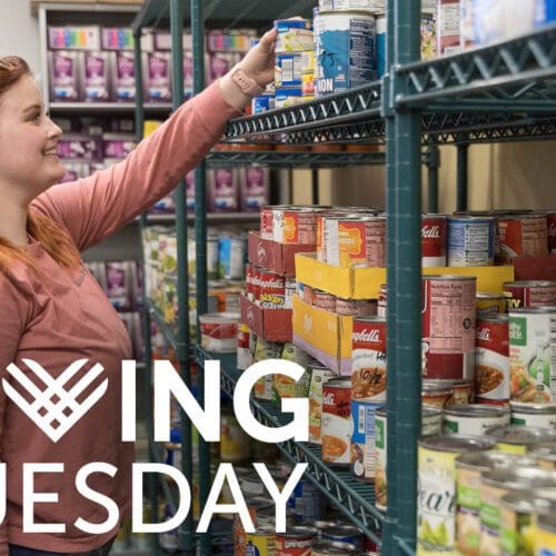 A student stocks shelves in the PNW Food Pantry. The Giving Tuesday logo is in the bottom left corner