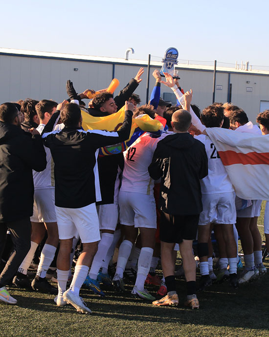 The PNW Men's Soccer team celebrates on the field after winning the GLIAC conference.