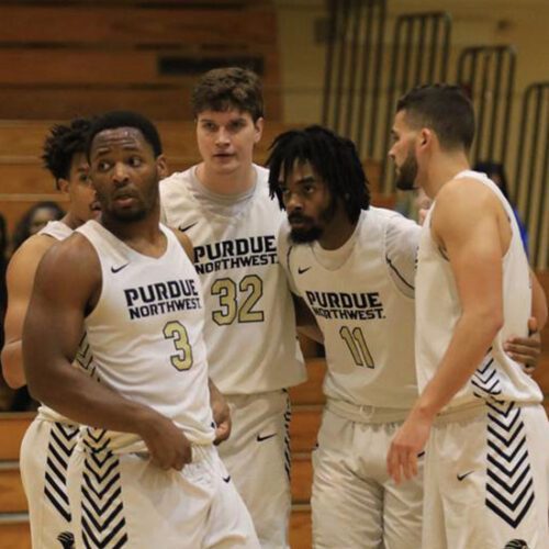Four PNW men's basketball players stand together in uniform