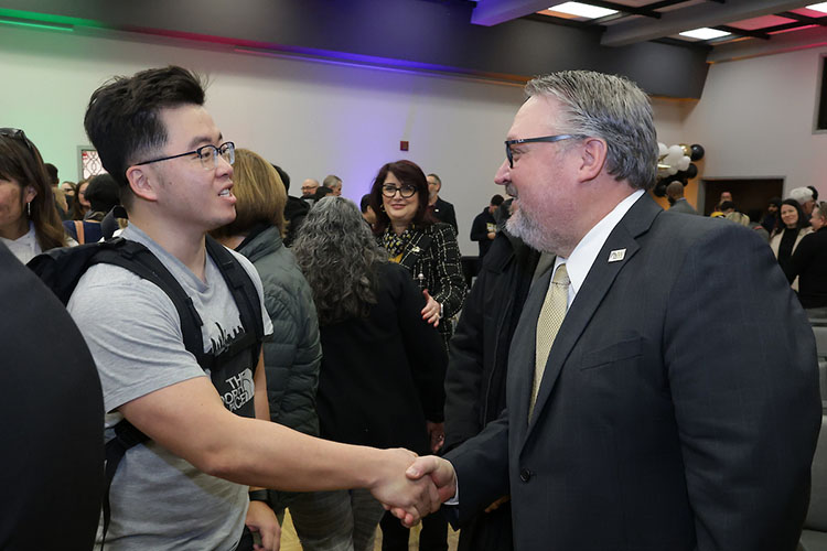 PNW Chancellor Chris Holford greets students in attendance at Excellence Evolving in Alumni Hall.