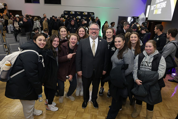 PNW Chancellor Chris Holford poses for a photo with members of the Pride softball team during the Excellence Evolving event in Alumni Hall.