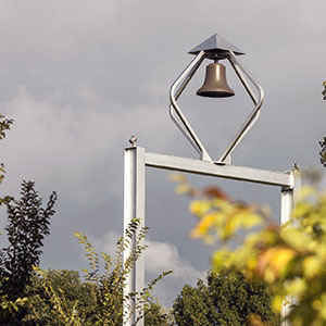 The PNW Bell Tower in front of tree foliage