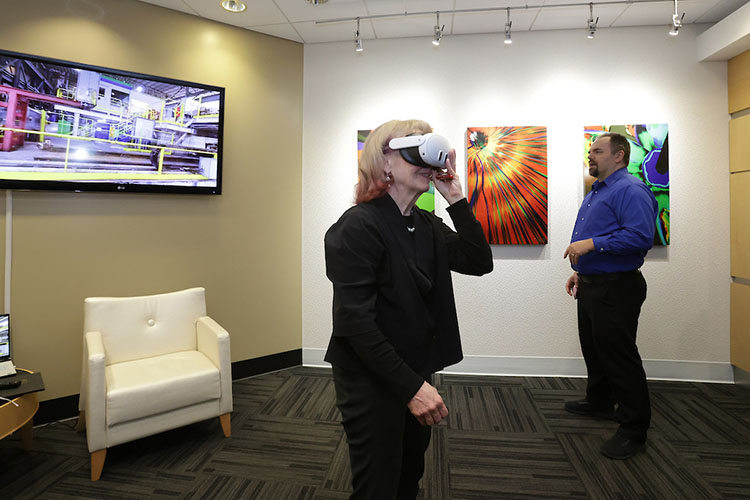 Geri Richmond, foreground, U.S. Department of Energy Under Secretary for Science and Innovation, demos a 3D visualization with the help of Jack Moreland, left, senior research scientist at CIVS.