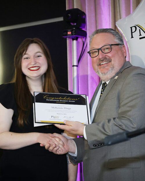PNW Chancellor Chris Holford shakes hands with Mackenzie Dinga as she recieves an "Outstanding Student" award.