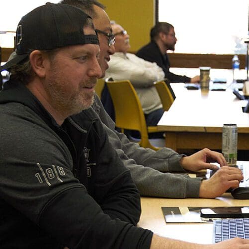 People sit at computers in a classroom