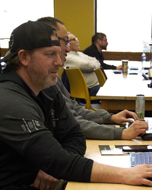 People sit at computers in a classroom