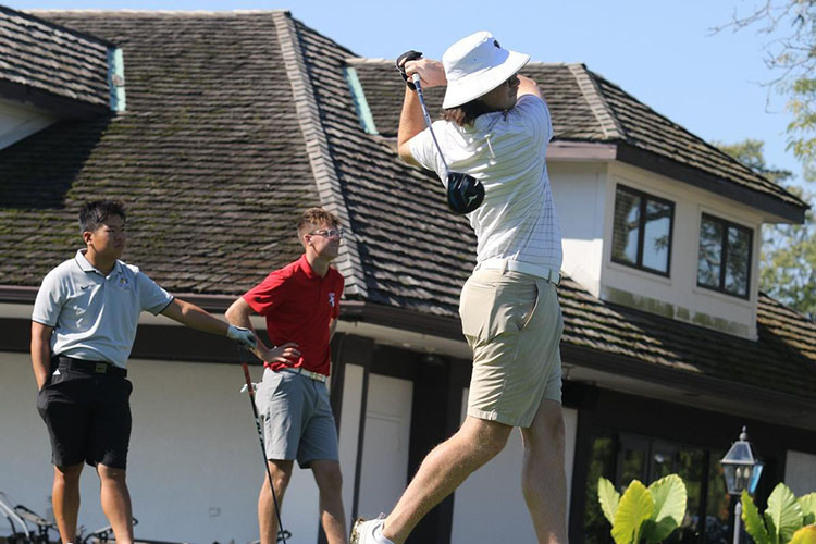 A golf player swings a club