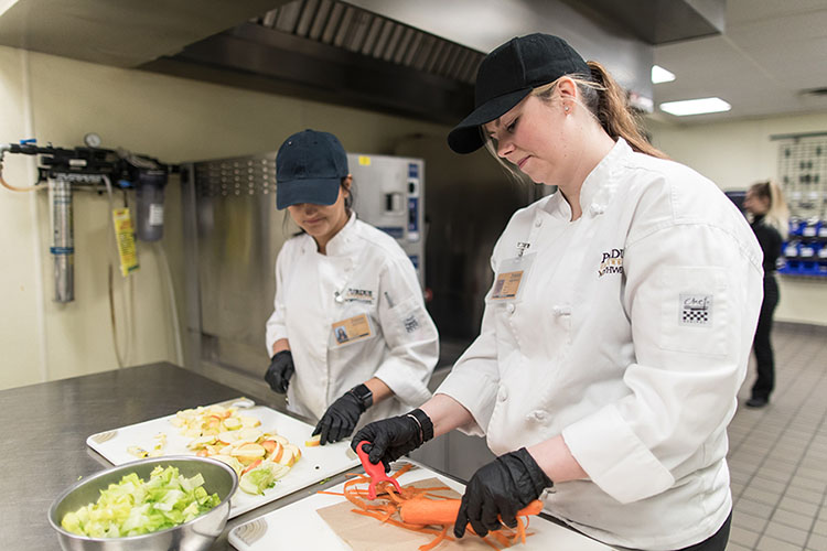 Chefs prep food in a professional kicthen