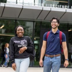 Two students walking together outside of the Nils Building