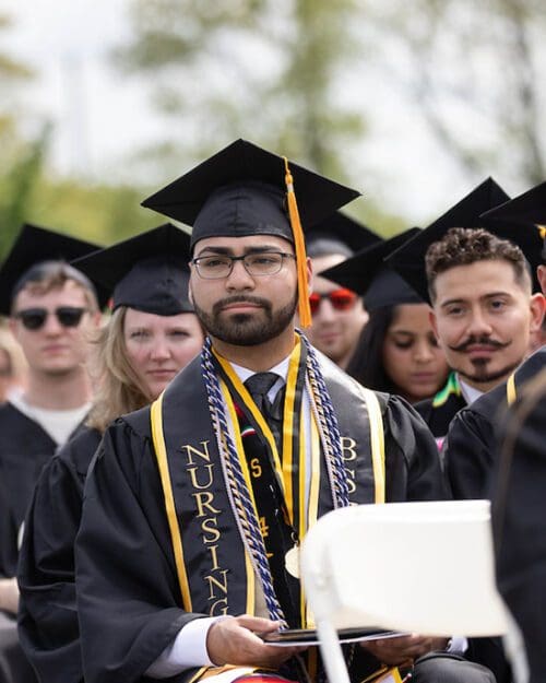 Students sit in commencement regalia during the Spring 2024 commencement ceremony