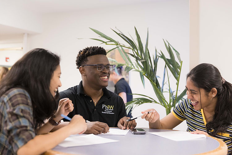 Students sit at a table in the University dorms