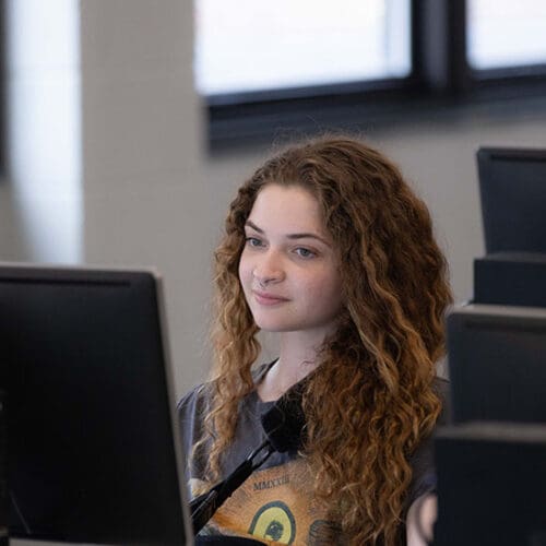 A student works on a desktop computer