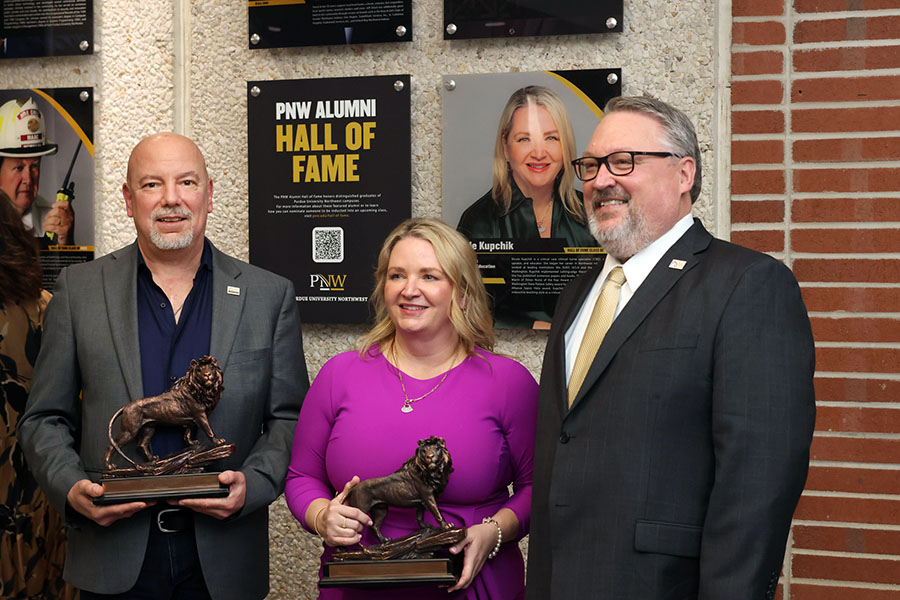 PNW Alumni Hall of Fame honorees Mitchell “Mason” Macenski and Nicole Kupchik pose with Chancellor Kenneth C. Holford at the induction ceremony.