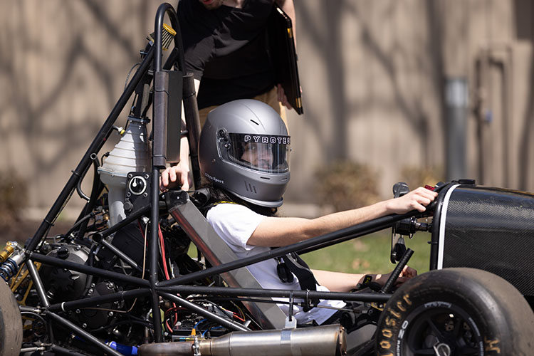 A student drives a motorsport vehicle.