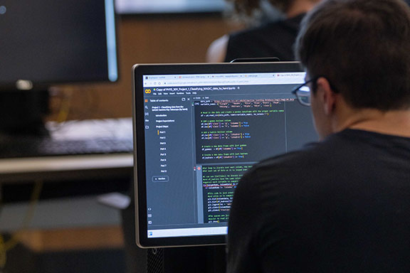 A student works on code on a computer