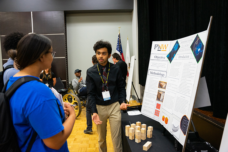 PNW Days of Discovery Photo - student talking to viewers over his project