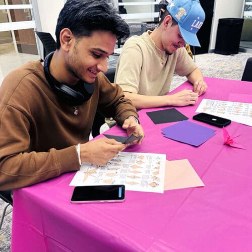 PNW student leaders fold cranes at a table