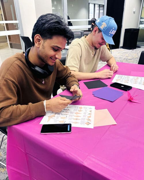 PNW student leaders fold cranes at a table