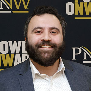 Omeed Ilchi in front of a PNW Power Onward banner