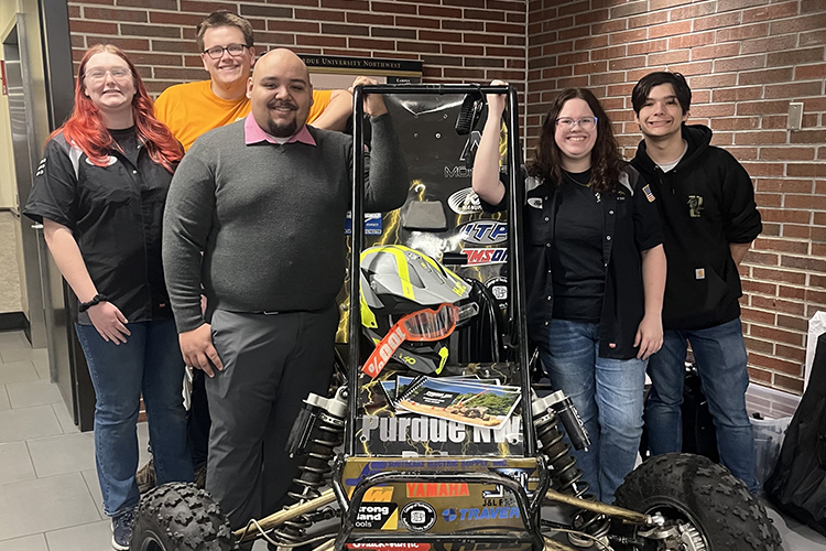 Technology Day 2025 - 5 students smiling with an automotive