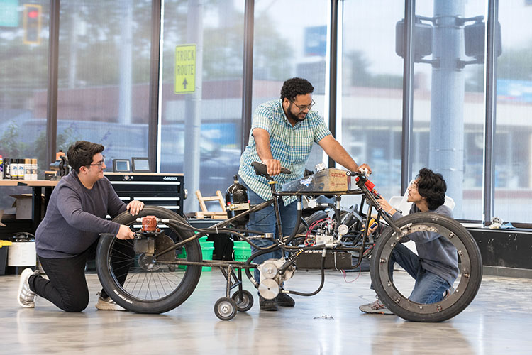 Students work on an electronic bike in the Commercialization and Manufacturing Excellence Center.