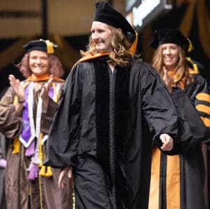 Kristina James walks across stage at commencement