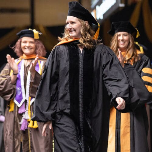 Kristina James walks across stage at commencement