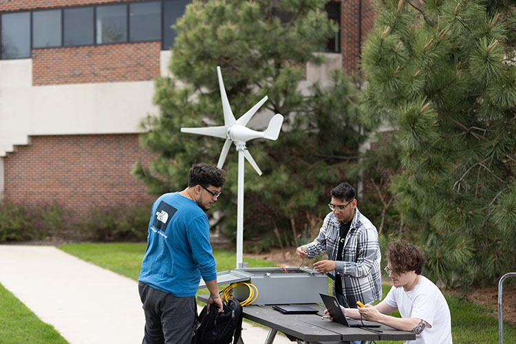 Students work on a wind project outdoors.