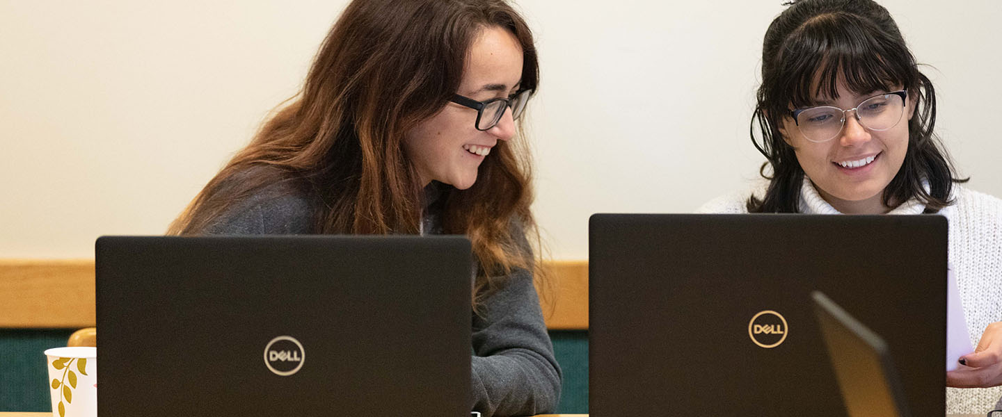 Two students work on computers during a class