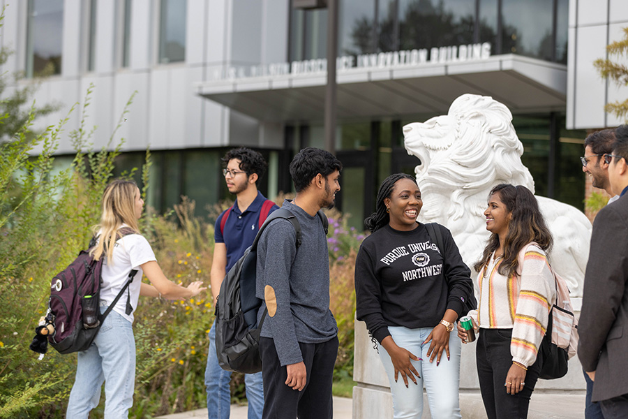 Seven students stand together outside of the Nils building