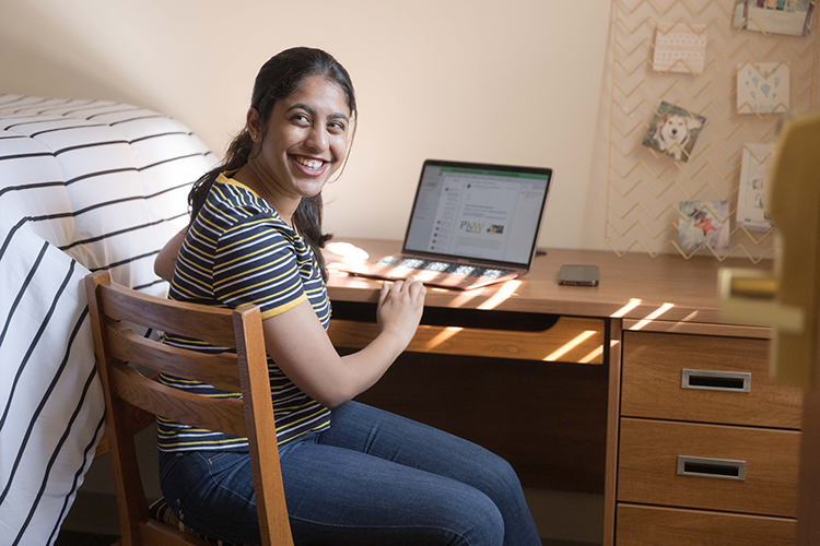 Student working on the computer in a dorm room