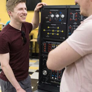 Two students work at a power electronics learning station