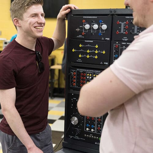Two students work at a power electronics learning station
