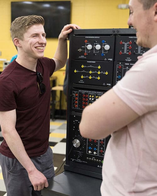 Two students work at a power electronics learning station