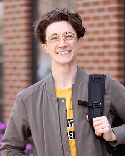A PNW student stands outdoors
