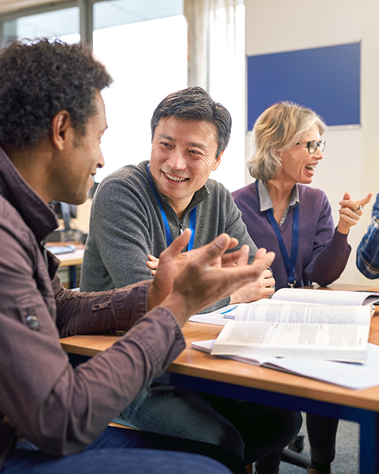 Adults hold a discussion around books