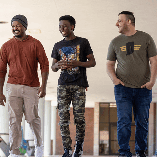 Three student veterans walk on campus