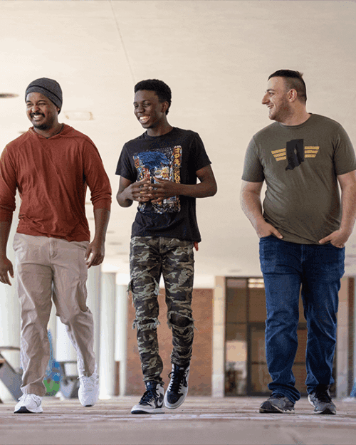 Three student veterans walk on campus