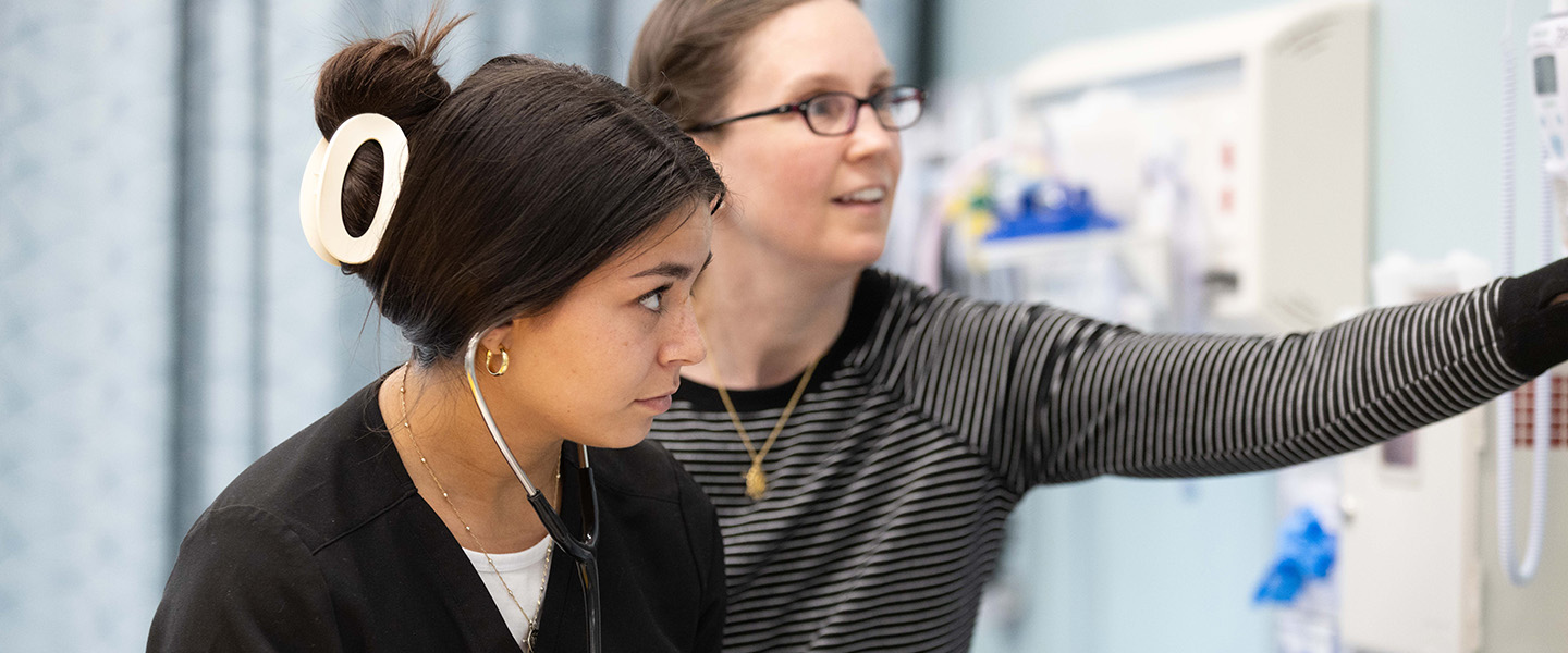A student and an educator work in a nursing lab