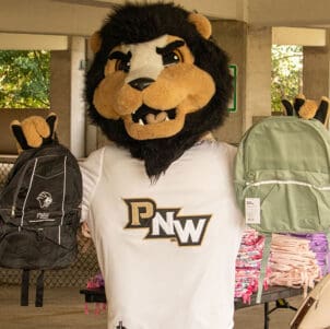 PNW Mascot Leo the Lion holds up two backpacks