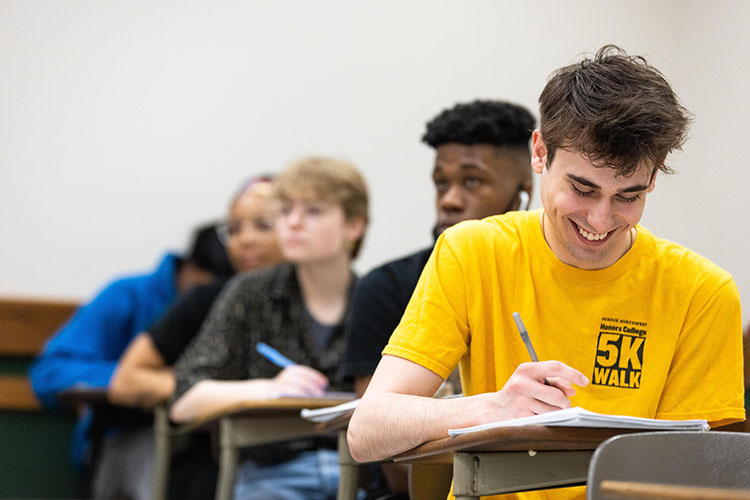 A student writes in a classroom