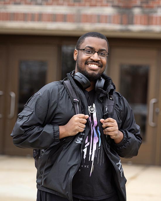 A PNW student stands outdoors in a jacket