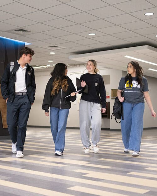 Four students walk through the Classroom Office Building