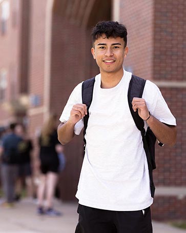 A PNW student poses in a backpack outdoors