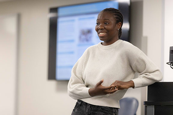 A student leans against a podium