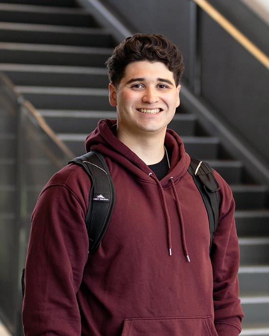 A PNW student stands indoors