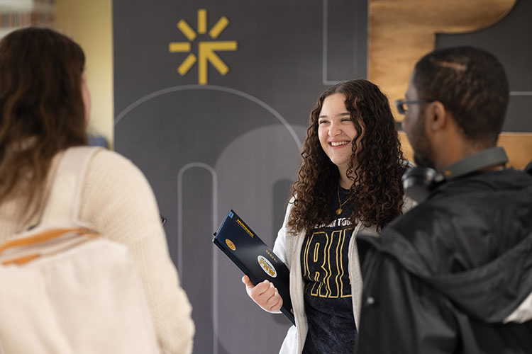 Three PNW students stand in the Classroom Office Building.