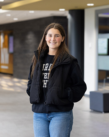 Ella, a PNW student, stands in the Classroom Office Building.