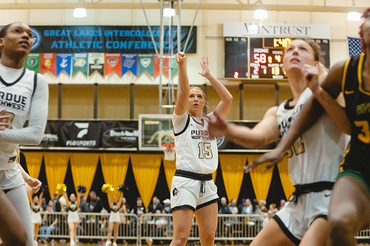 PNW Women's Basketball team. Player in white jersey shooting the basketball